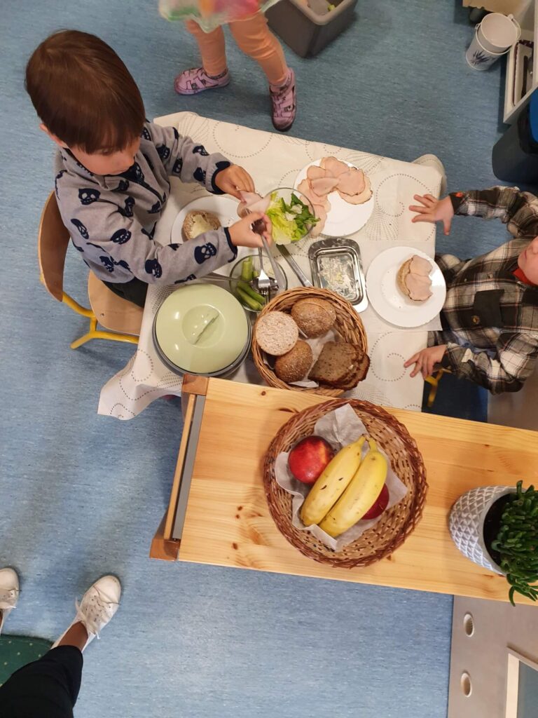 Montessoriańskie śniadanie - Dzieci samodzielnie nakładają produkty na talerz