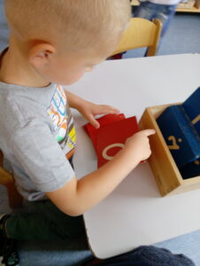 Trzyletnie Dziecko w przedszkolu Montessori Chatka poznaje pierwsze litery