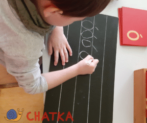 Czterolatek w Przedszkolu Montessori Chatka na warszawskim Ursynowie ćwiczy pisanie