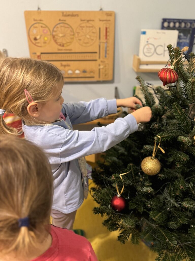 Przedszkolaki wspólnie ubierają choinkę
bożonarodzeniową