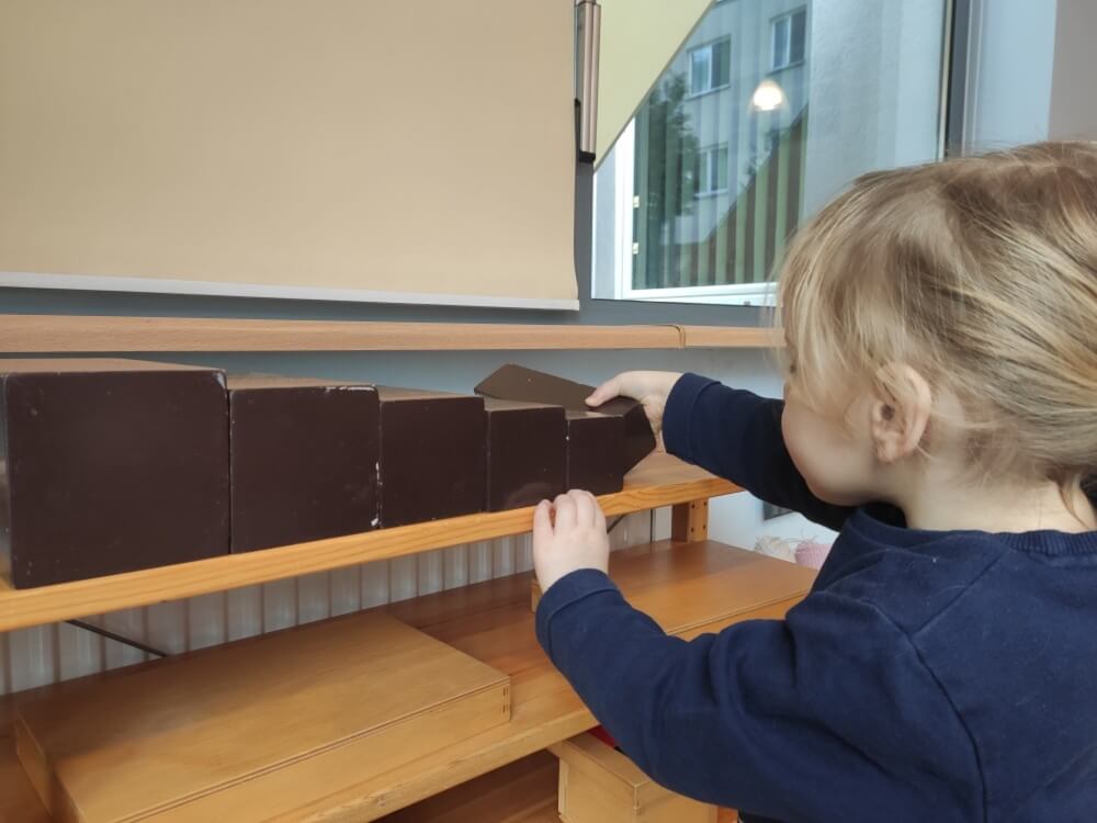 Dziecko ustawiające pudełka według ich wielkości